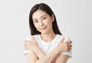 目を閉じ、愛おしそうに自分を抱きしめるセルフラブの様子。夫との心の距離に孤独を感じる時こそ、まずは自分の感情に気づき、本音を大切にすることで内面から癒やされていく過程を表現した共感性の高いカット。